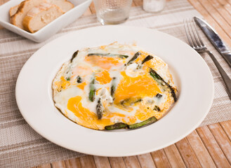 Closeup of fried eggs with asparagus at plate