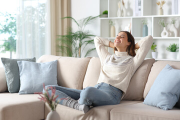 Happy woman in winter relaxing sitting at home