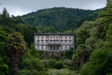 Fototapeta premium Elegant historic chateau in a lush forest garden