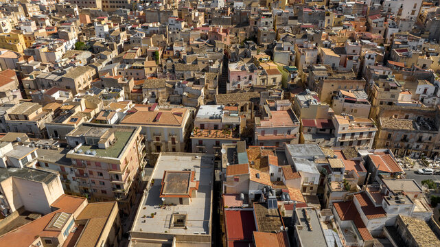 Aerial view of houses, apartments, and buildings in the historic center of Sciacca, in the province of Agrigento, Sicily, Italy. It's a beautiful, sunny summer day.