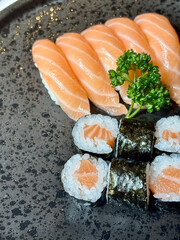 An incredibly delicious selection of sushi and rolls, a variety of fish, raw fish, avocado, wasabi, soy sauce, sesame seeds, chopsticks, Japanese food.