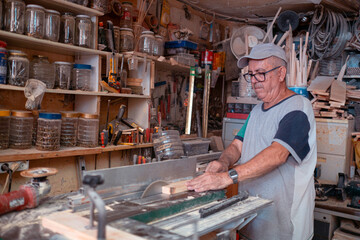 Senior man cutting wood using an electric table saw