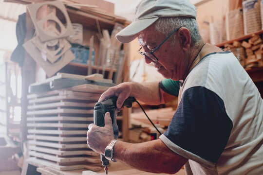 Senior artisan crafting wood in workshop using drill tool - Powered by Adobe