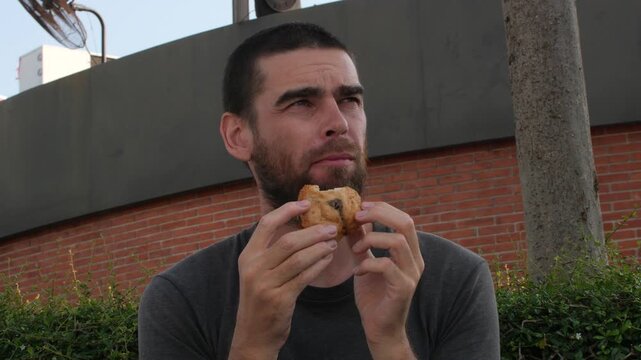Close-Up Portrait of Man Eating Chicken Piece Outdoors