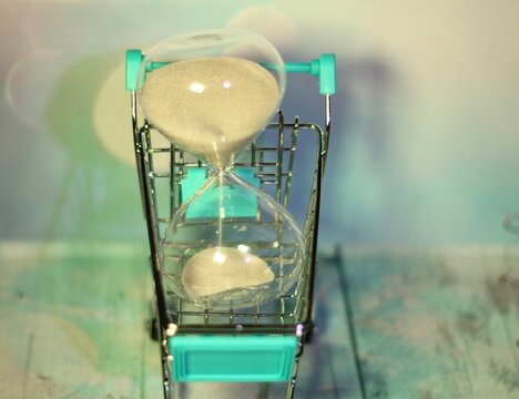  Hourglass in the shopping cart trolley concept photo buying time