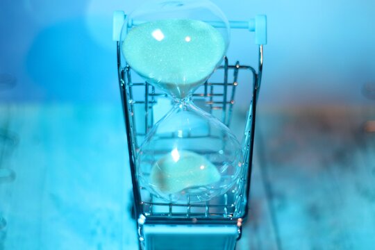 Hourglass in the shopping cart trolley concept photo buying time