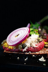 Close-up of Danish smorrebrod, open rye sandwich with ground beef steak tartare.