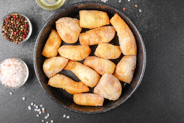 Garlic breadsticks in black bowl on dark background for appetizer, snack or pizza side concept