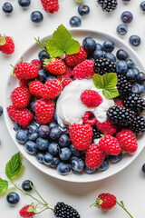 A delightful bowl of creamy yogurt topped with fresh blueberries and raspberries, perfect for a healthy snack or breakfast