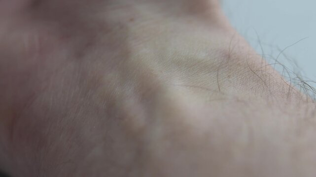 Fingers gently pressed to wrist in macro view as pulse beats under skin, clearly illustrating self-monitoring of heart rate.