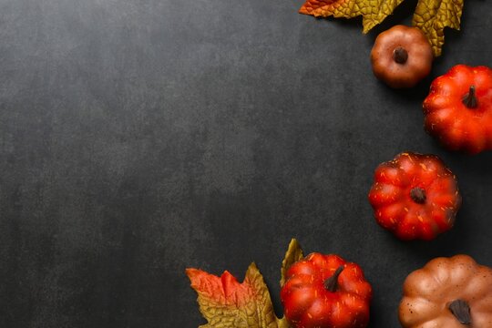 A festive autumn flat lay with pumpkins and leaves on a black concrete background. Thanksgiving greeting card design. Autumn fall - Powered by Adobe