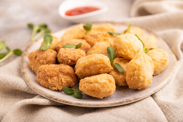 Fried crispy Chicken Nuggets with ketchup, microgreen on brown concrete. Diet, healthy eating. side view, selective focus
