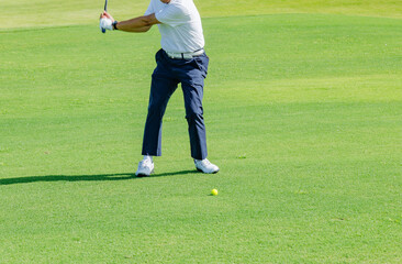緑が綺麗なゴルフ場でプレイする人