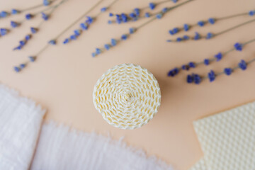 Lavender bouquet with beeswax sheets and candle on fabric and pastel background