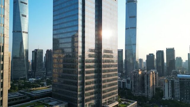 Aerial shot of a modern city with towering glass skyscrapers and surrounding buildings