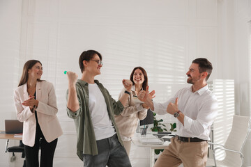 Group of colleagues playing darts in office