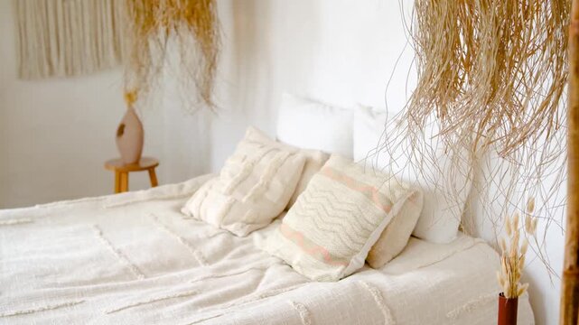 Serene bedroom with natural decor, soft pillows on white bedding, boho style