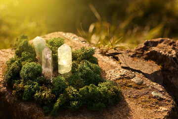 Aura. Beautiful healing crystals and moss on stone outdoors, closeup. Space for text