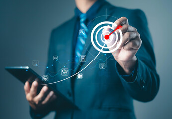 Businessman using tablet and touching digital target icon with growth curve, representing goal achievement, business success, marketing strategy, and performance analytics in modern technology.