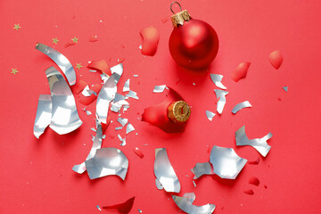 Pieces of broken Christmas ornaments on red background, flat lay