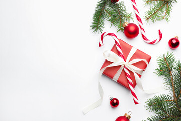 Fir tree branches, gift box and Christmas decor on white background, flat lay. Space for text