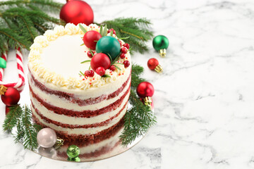 Delicious sponge cake with Christmas decor and red currants on white marble table, closeup. Space for text