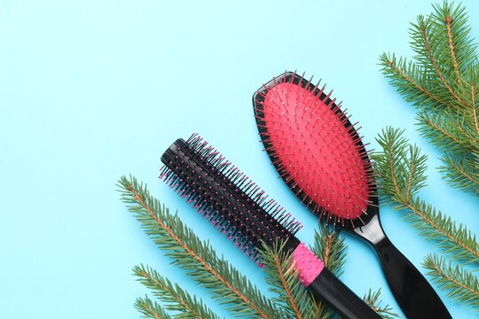 Hairdresser's tools and fir tree branches on light blue background, flat lay with space for text. Christmas greeting card - Powered by Adobe