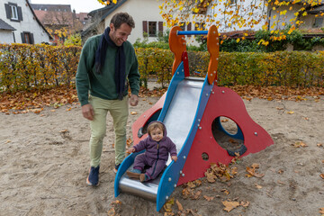 Papa mit Kleinkind auf dem Spielplatz