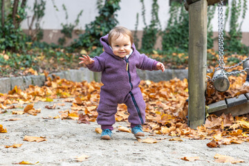 Baby spielt vergn&uuml;gt im Herbstlaub