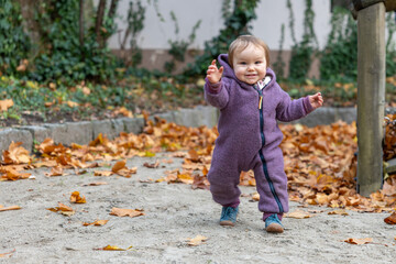 Baby spielt vergn&uuml;gt im Herbstlaub