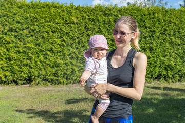 Mama mit Babytochter drau&szlig;en im Garten