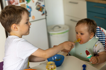 Bruder f&uuml;ttert Baby-Schwester