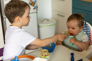 Bruder f&uuml;ttert Baby-Schwester