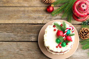 Tasty cake with Christmas decor on wooden table, flat lay. Space for text