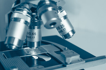 High-quality close-up image of a laboratory microscope being adjusted by a scientist in gloves. Represents science precision, healthcare innovation, and biotechnology research.
