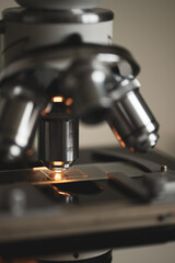 High-quality close-up image of a laboratory microscope being adjusted by a scientist in gloves. Represents science precision, healthcare innovation, and biotechnology research.