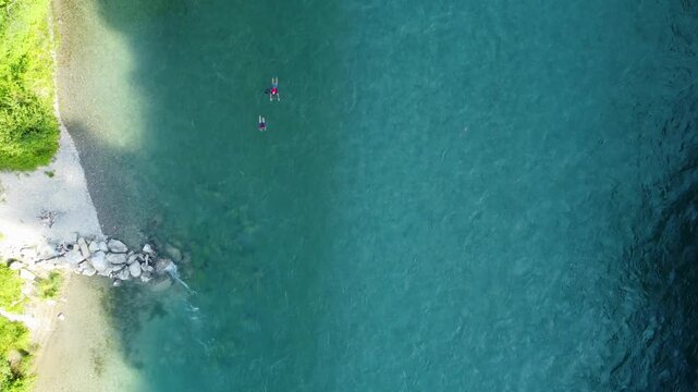 Drone footage in zenithal view of people enjoying the current in the Aar river, Switzerland