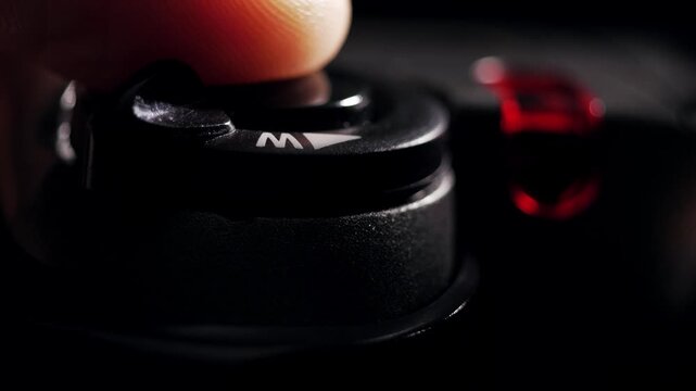 Macro shot of finger pressing shutter button on digital camera with flash firing