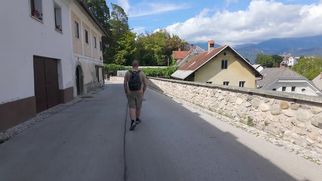 Tourist man from behind strolling through the pretty streets of Radovljica, Slovenia.