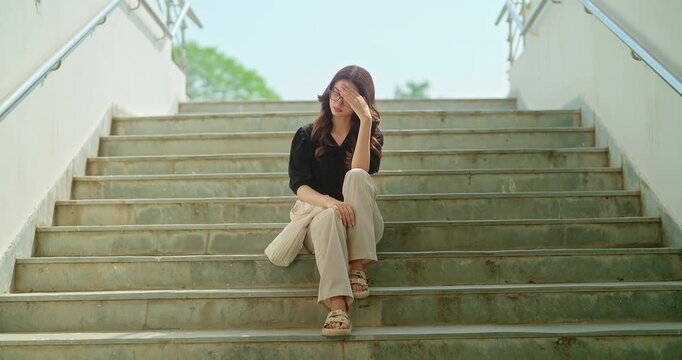 Indian young adult gen z upset female sitting alone on stair failed in exam feel bad low at campus place. Sad tense teen girl wear glass suffer course study have learning issue stress hostel life