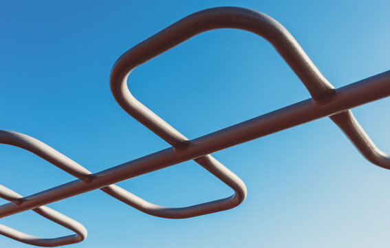 abstract pattern connecting metal curved pipes against a blue sky background