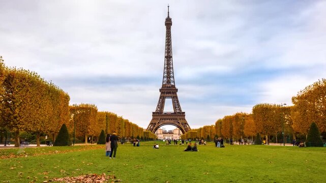 Time lapse view of the park in front of the Eiffel Tower in Paris, France, with autumn leaves and motion blurred people enjoying the view
