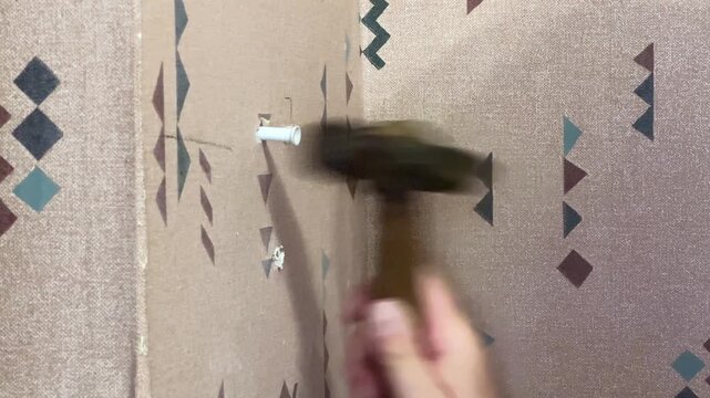 Installing dowel to appropriate hole in wall and hammering it