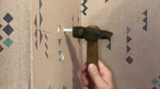 Installing dowels to appropriate holes in wall and hammering it