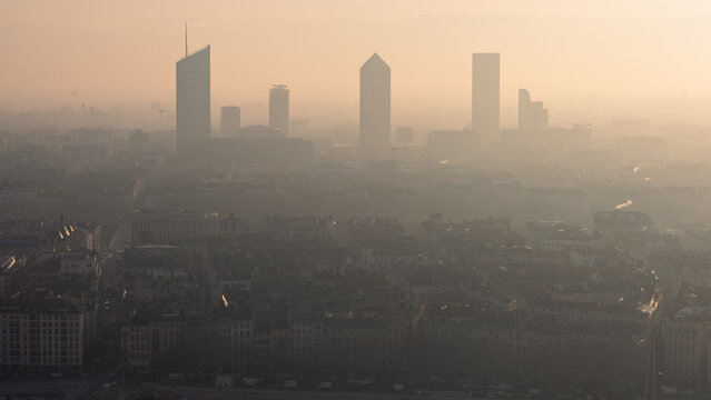 grande ville fran&ccedil;aise avec pollution atmosph&eacute;rique, pollution dans l'air &agrave; Lyon, brume au lever du soleil sur des tours d'une ville