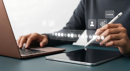 Person working on laptop and tablet with digital interface.