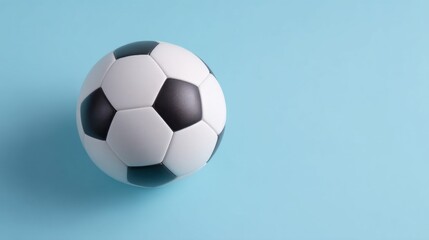 Naklejka premium A classic black and white soccer ball rests on a modern bright blue background. The smooth surface gives a playful and energetic vibe perfect for sports enthusiasts