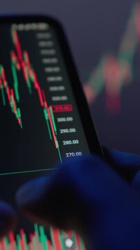 A closeup image shows hands gripping a smartphone displaying important stock market data, highlighting the vibrant trading dynamics and easy access to market analysis on digital platforms