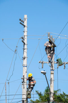 Equipe de manuten&ccedil;&atilde;o da constru&ccedil;&atilde;o civil fazendo troca de fios da rede el&eacute;trica, em cima do guindaste realizado troca de equipamentos de alta tens&atilde;o