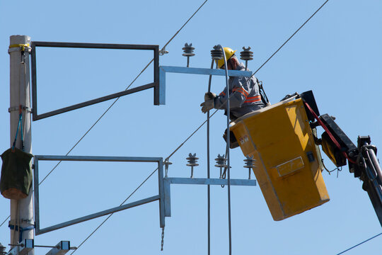 Retrato de trabalhador da constru&ccedil;&atilde;o civil fazendo manuten&ccedil;&atilde;o da rede el&eacute;trica, em cima do guindaste realizado troca de equipamentos de alta tens&atilde;o